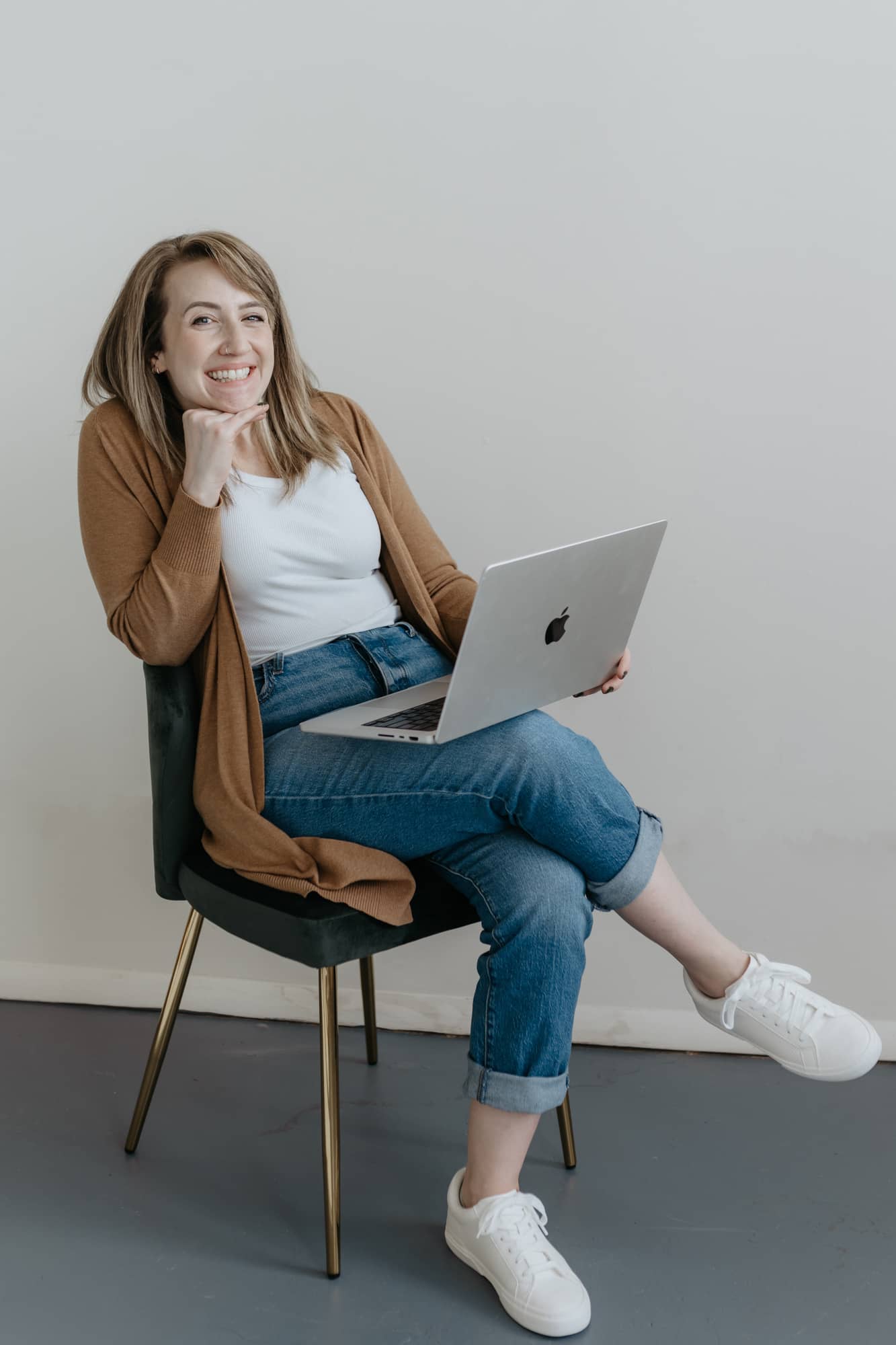 Hayley Rissler from CopyClick Studio sitting on a chair with a laptop