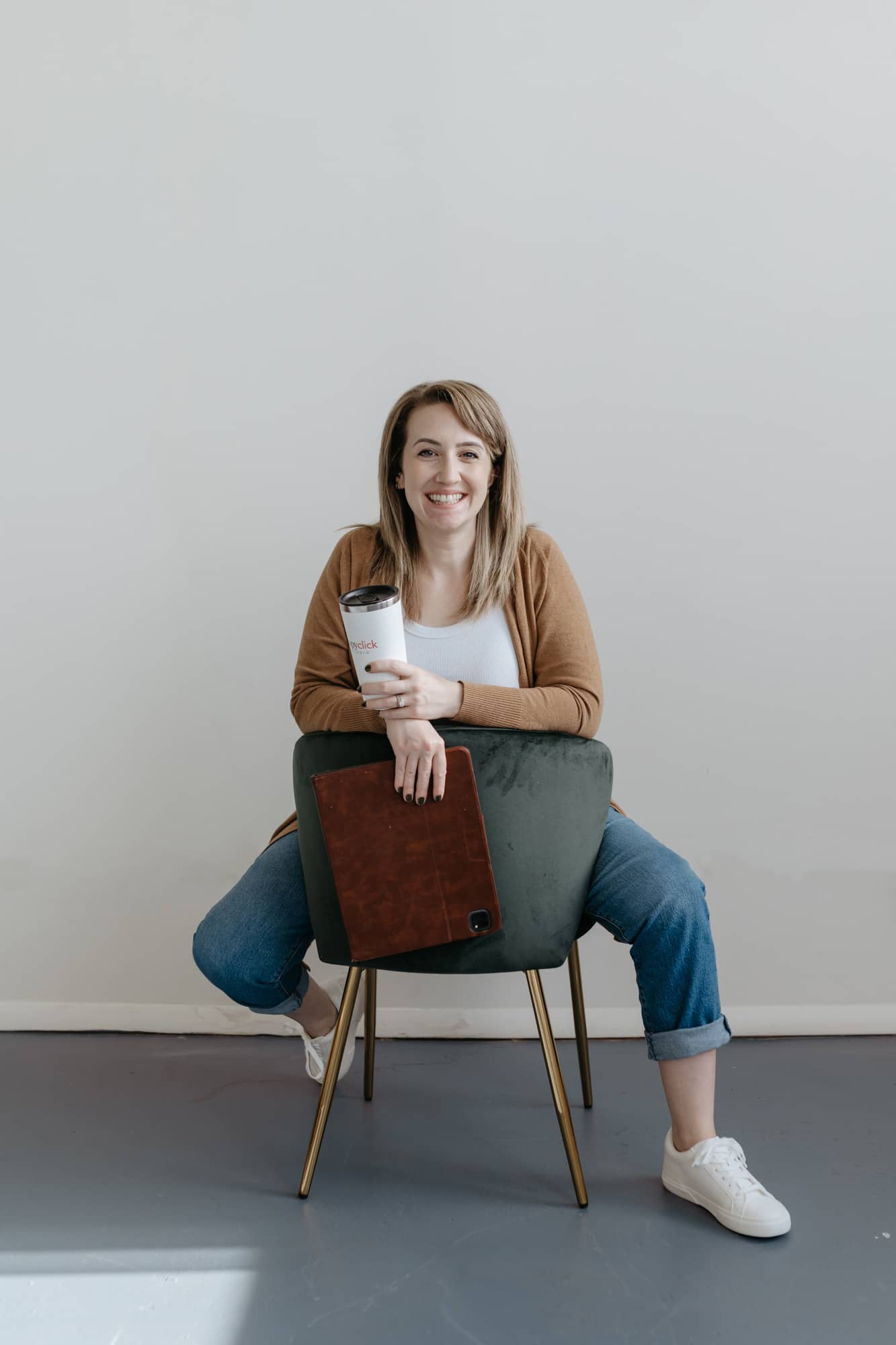 Hayley Rissler from CopyClick Studio sitting backwards on a chair smiling