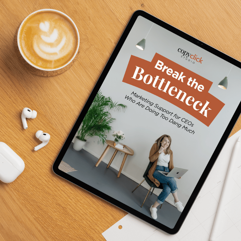 Break the Bottleneck cover on an iPad sitting on a wood desk next to airpods and a latte.